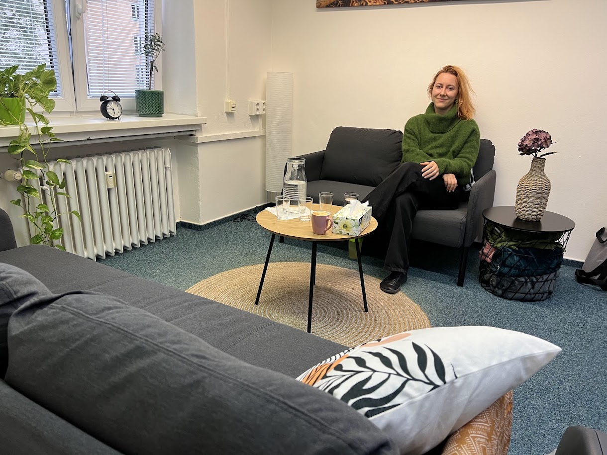 Barbora v konzultační místnosti s pohodlným sezením a stolkem.